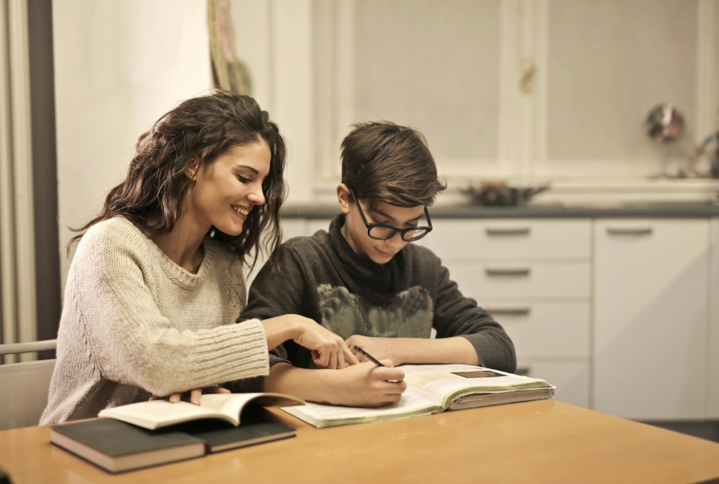 Mutter, die Kind bei Hausaufgaben hilft